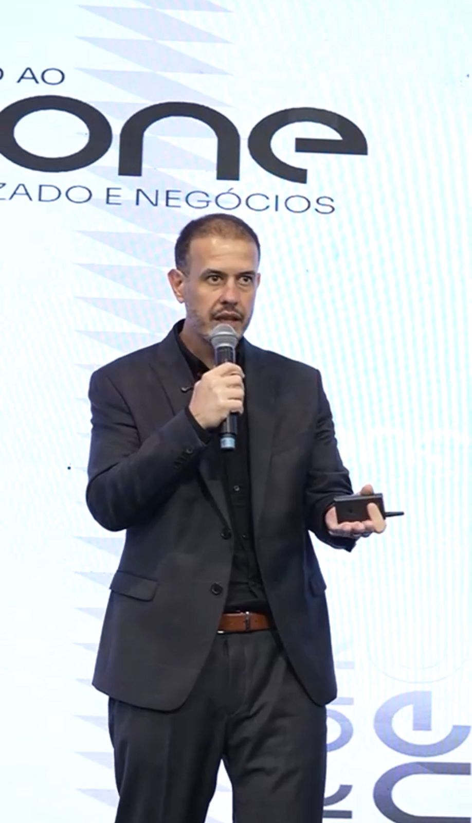 Fábio Barboni em palco da ONE com imagem vertical e contexto institucional claro